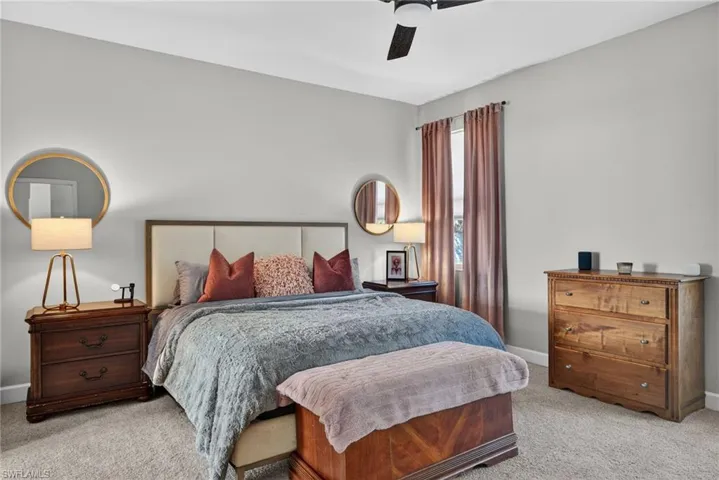 Bedroom with light colored carpet and ceiling fan