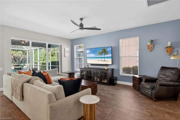Living area featuring hardwood / wood-style flooring, a ceiling fan, and a sunroom