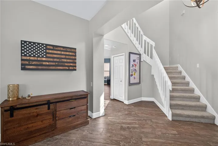 Foyer entrance with stairway and dark wood-style floors