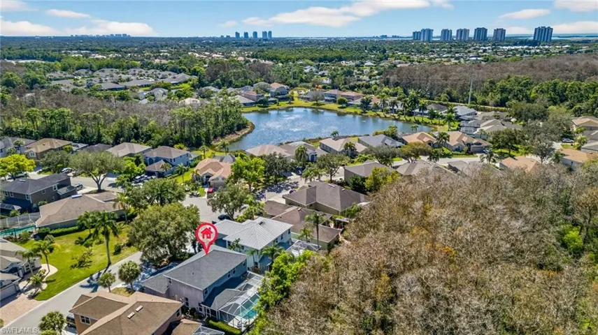 Aerial perspective of suburban area featuring a large body of water and city skyline