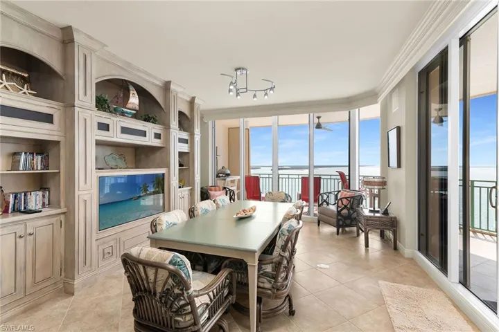 Dining space featuring ornamental molding, light tile patterned floors, floor to ceiling windows, and built in features