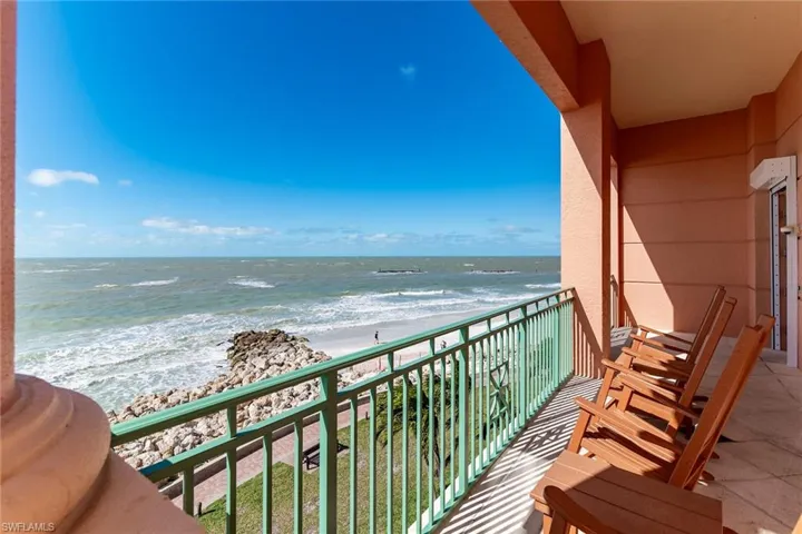 Balcony featuring view of water and beach