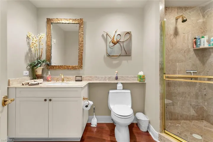 Bathroom featuring vanity, a stall shower, and dark wood-style flooring