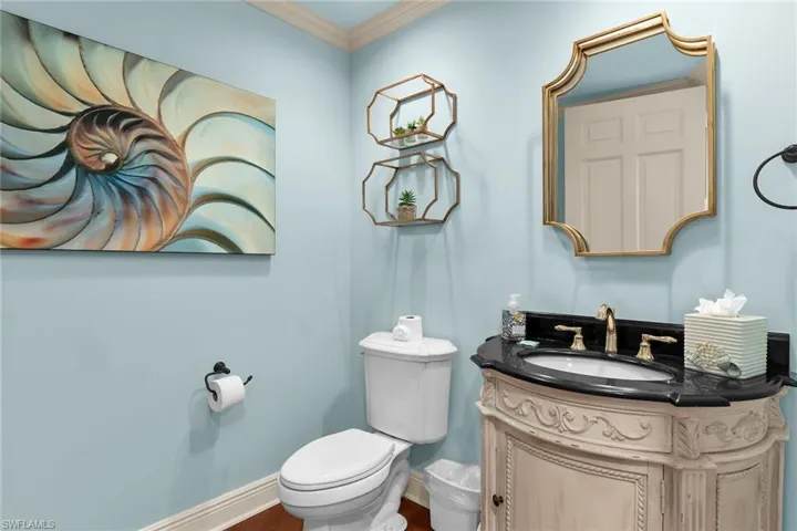 Bathroom with vanity, crown molding, and wood finished floors