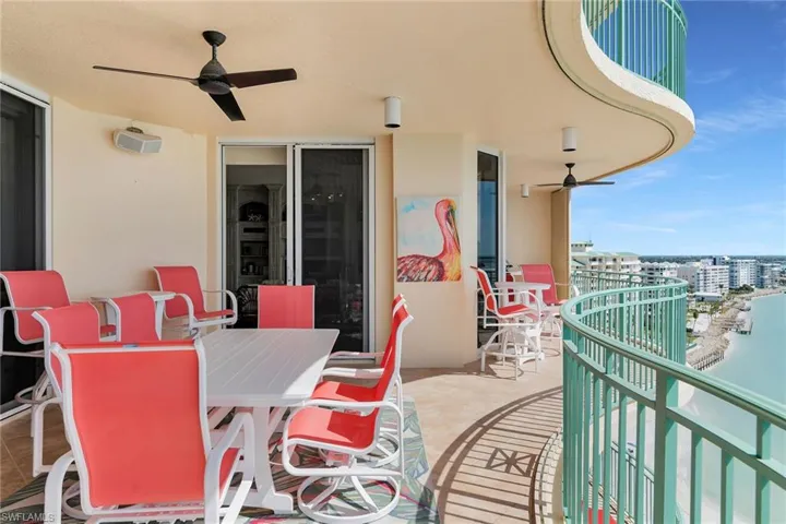 Balcony featuring a ceiling fan, outdoor dining area, and a water view