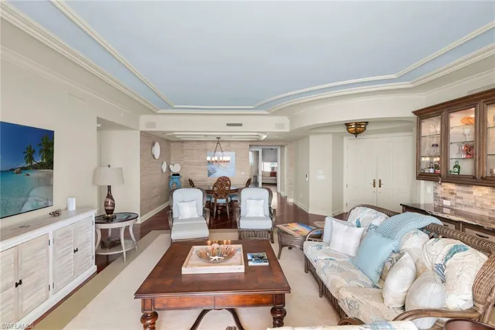 Living room featuring wood finished floors, suspended lighting, and arched walkways