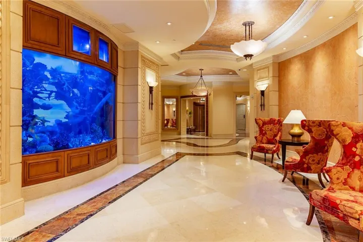 Building lobby featuring a raised ceiling, ornamental molding, and recessed lighting