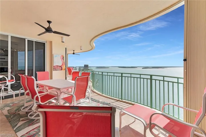 Balcony featuring a ceiling fan, a water view, and outdoor dining area