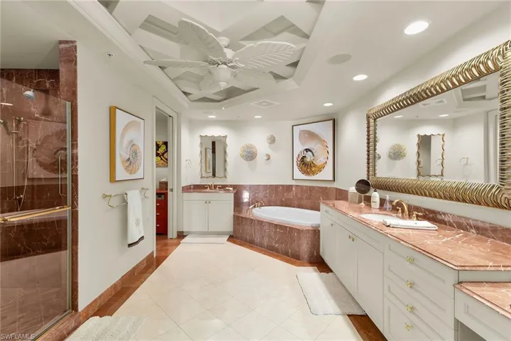 Full bath with a garden tub, two vanities, a shower stall, a ceiling fan, and light tile patterned floors