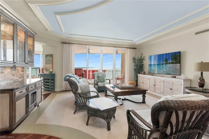 Living room with a raised ceiling and ornamental molding