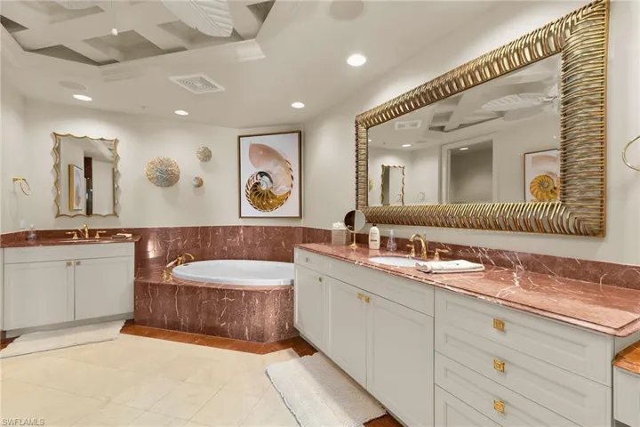 Full bath with coffered ceiling, two vanities, a bath, recessed lighting, and light tile patterned floors
