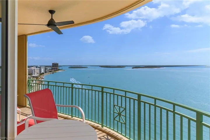 Balcony featuring ceiling fan and a water view