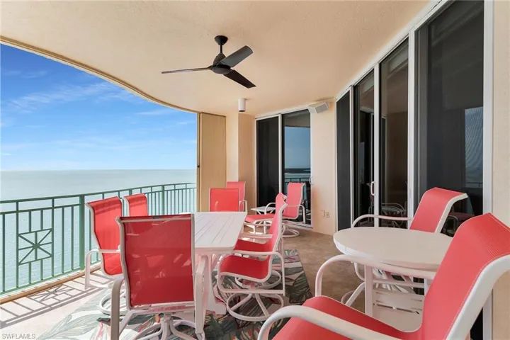 Balcony with a ceiling fan, a water view, and outdoor dining space