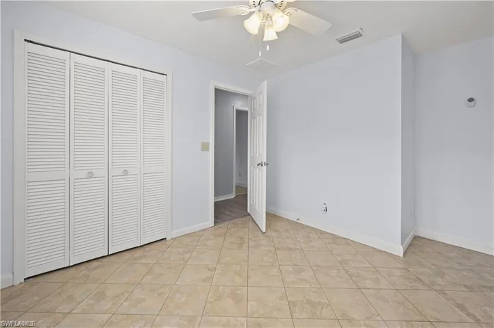 Unfurnished bedroom featuring ceiling fan, a closet, and light tile patterned floors