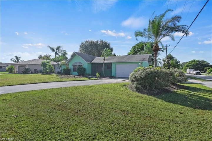 View of front of home featuring a garage and a front lawn