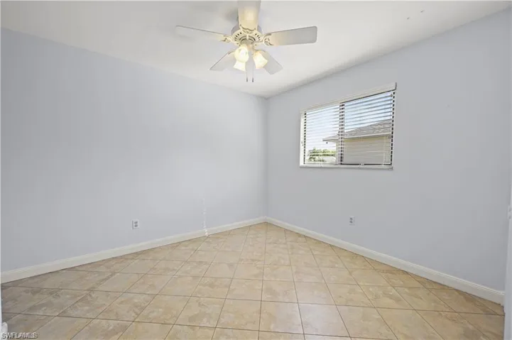 Unfurnished room with light tile patterned flooring and ceiling fan