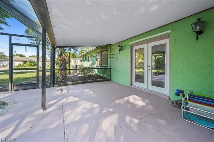 Unfurnished sunroom featuring vaulted ceiling and french doors