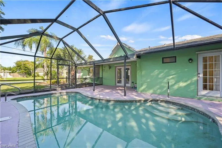 View of swimming pool with a lanai, french doors, and a patio area
