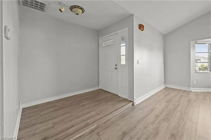 Foyer entrance featuring lofted ceiling and light hardwood / wood-style floors
