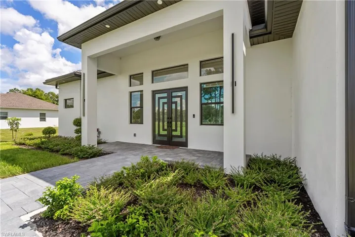 Doorway to property with stucco siding and french doors