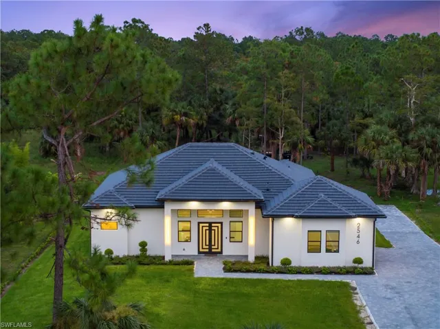 View of front of house featuring french doors, a tiled roof, a front yard, and stucco siding