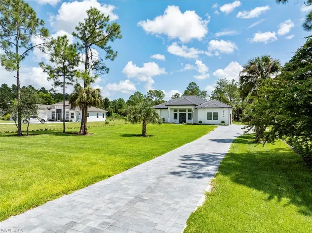 View of front of property with a front yard and driveway