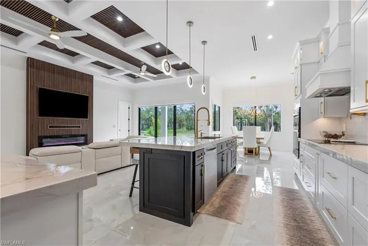 Kitchen with marble finish floor, a sink, backsplash, and dark cabinets
