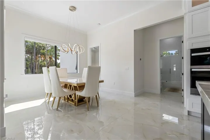 Dining room featuring marble finish floor, crown molding, and baseboards