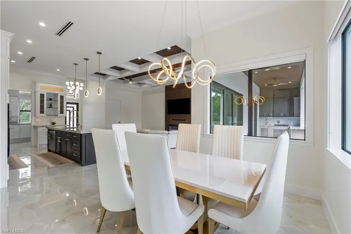 Dining area featuring marble finish floor, a notable chandelier, baseboards, and recessed lighting