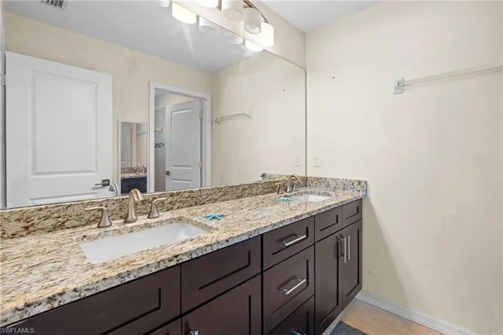 Full bathroom with double vanity and baseboards