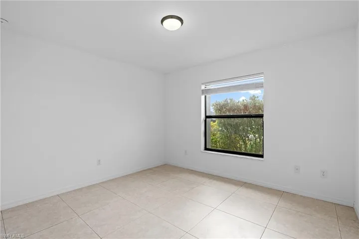 Spare room featuring baseboards and light tile patterned floors