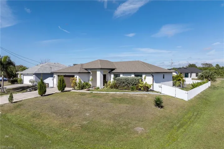 View of front of house with concrete driveway, stucco siding, an attached garage, and a shingled roof