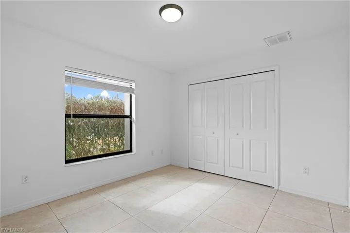 Unfurnished bedroom with light tile patterned flooring and a closet