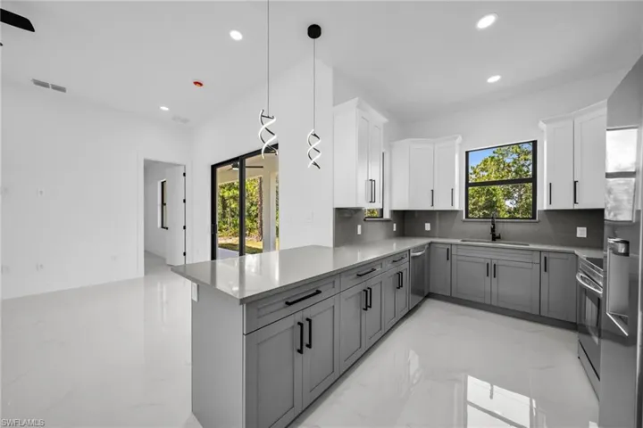 Kitchen with stainless steel appliances, tasteful backsplash, plenty of natural light, light marble finish floors, and recessed lighting