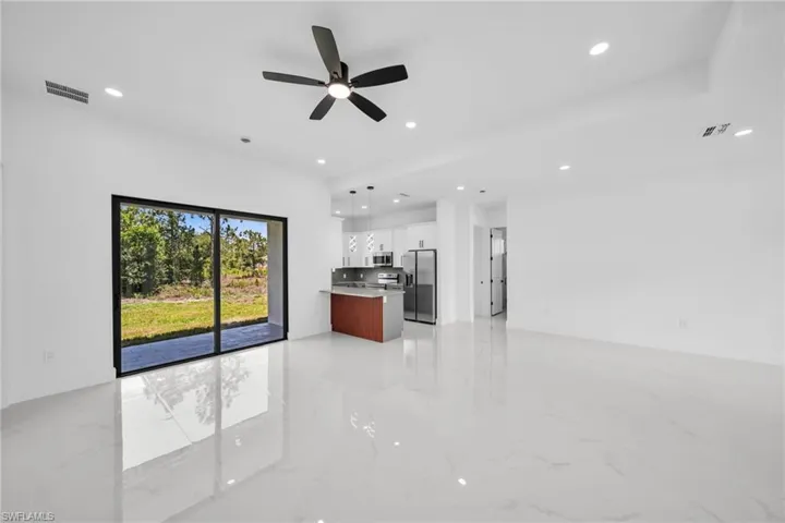 Unfurnished living room with recessed lighting, light marble finish floors, and ceiling fan