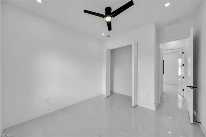 Unfurnished bedroom featuring light marble finish flooring, recessed lighting, and a ceiling fan