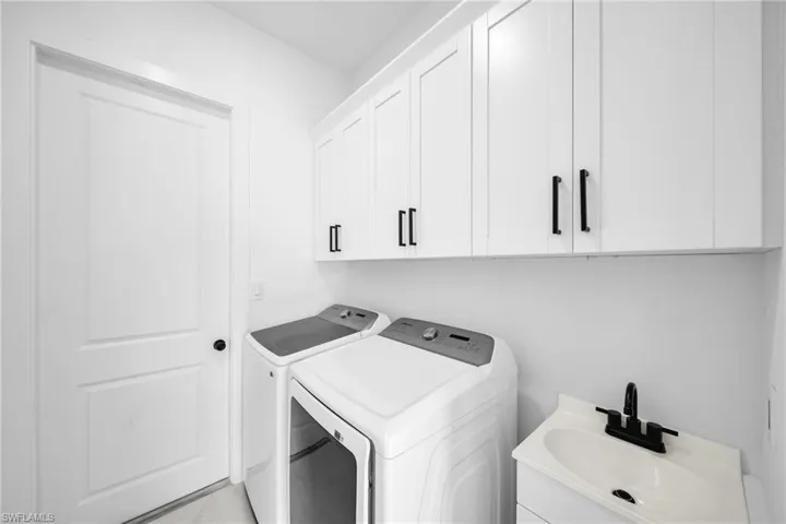 Laundry room featuring separate washer and dryer and cabinet space