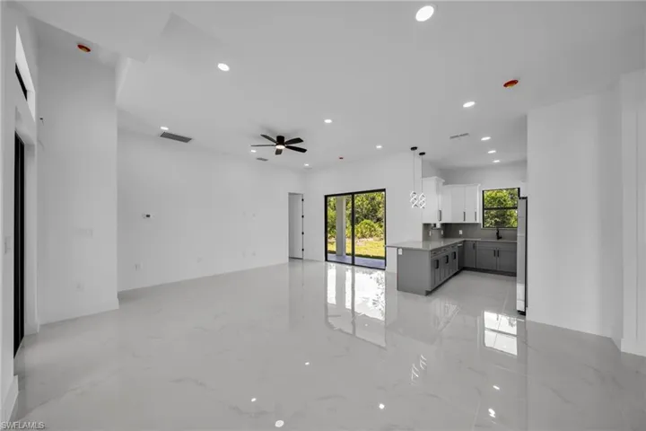Unfurnished living room with recessed lighting, light marble finish floors, and a ceiling fan