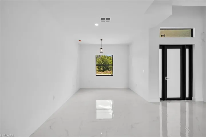 Empty room featuring light marble finish floors and recessed lighting