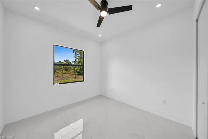 Empty room featuring light marble finish flooring, recessed lighting, and ceiling fan
