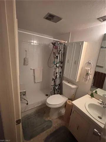 Bathroom with vanity, a stall shower, and a textured ceiling