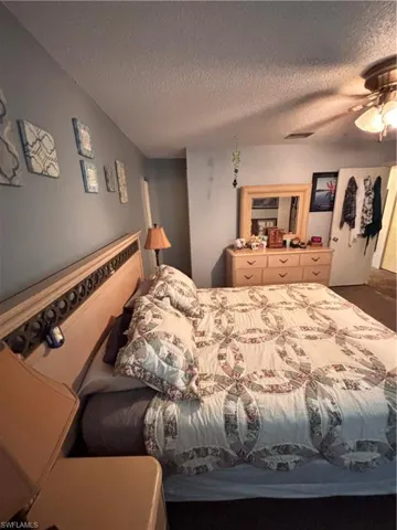 Bedroom featuring a ceiling fan and a textured ceiling