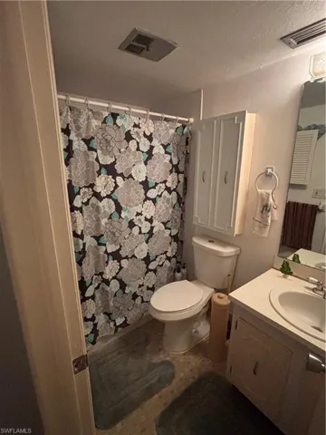 Bathroom with vanity, curtained shower, and a textured ceiling
