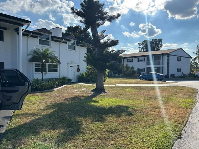 View of front of property featuring a front yard and stucco siding