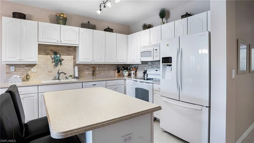 Kitchen with sink, white appliances, and white cabinets