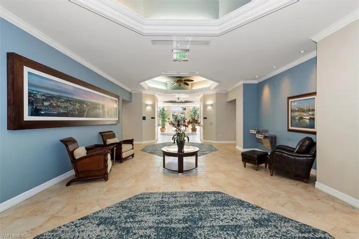 Lobby with a raised ceiling and crown molding