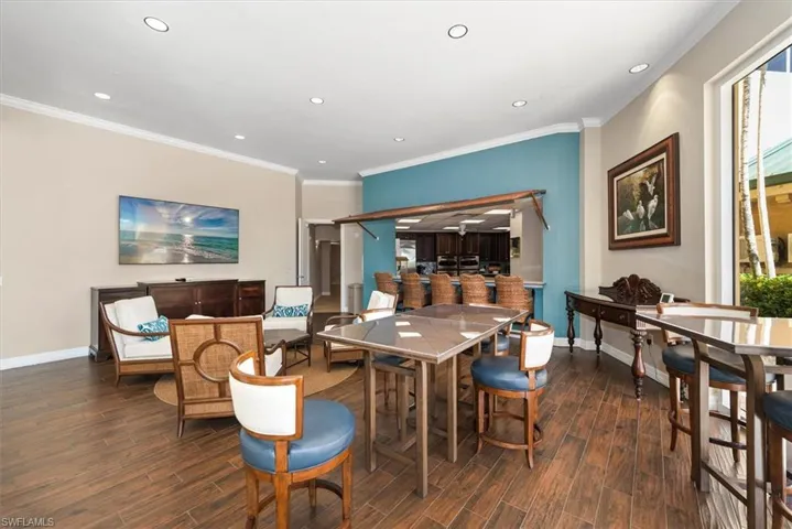 Dining area with dark wood-style flooring, crown molding, and recessed lighting