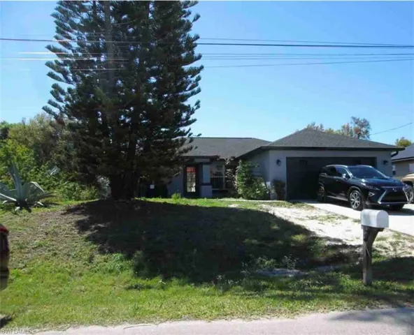 View of front of house featuring a garage, a front yard, and driveway
