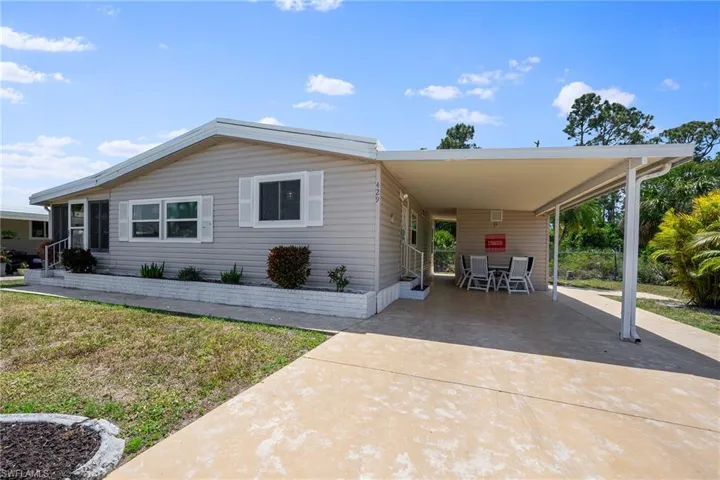 Manufactured / mobile home with entry steps, an attached carport, and concrete driveway