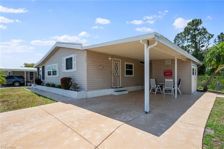 Manufactured / mobile home with a carport, driveway, and entry steps